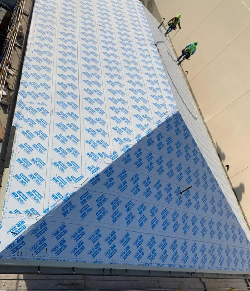 Professional roofers installing underlayment on a metal roof in Grand Blanc